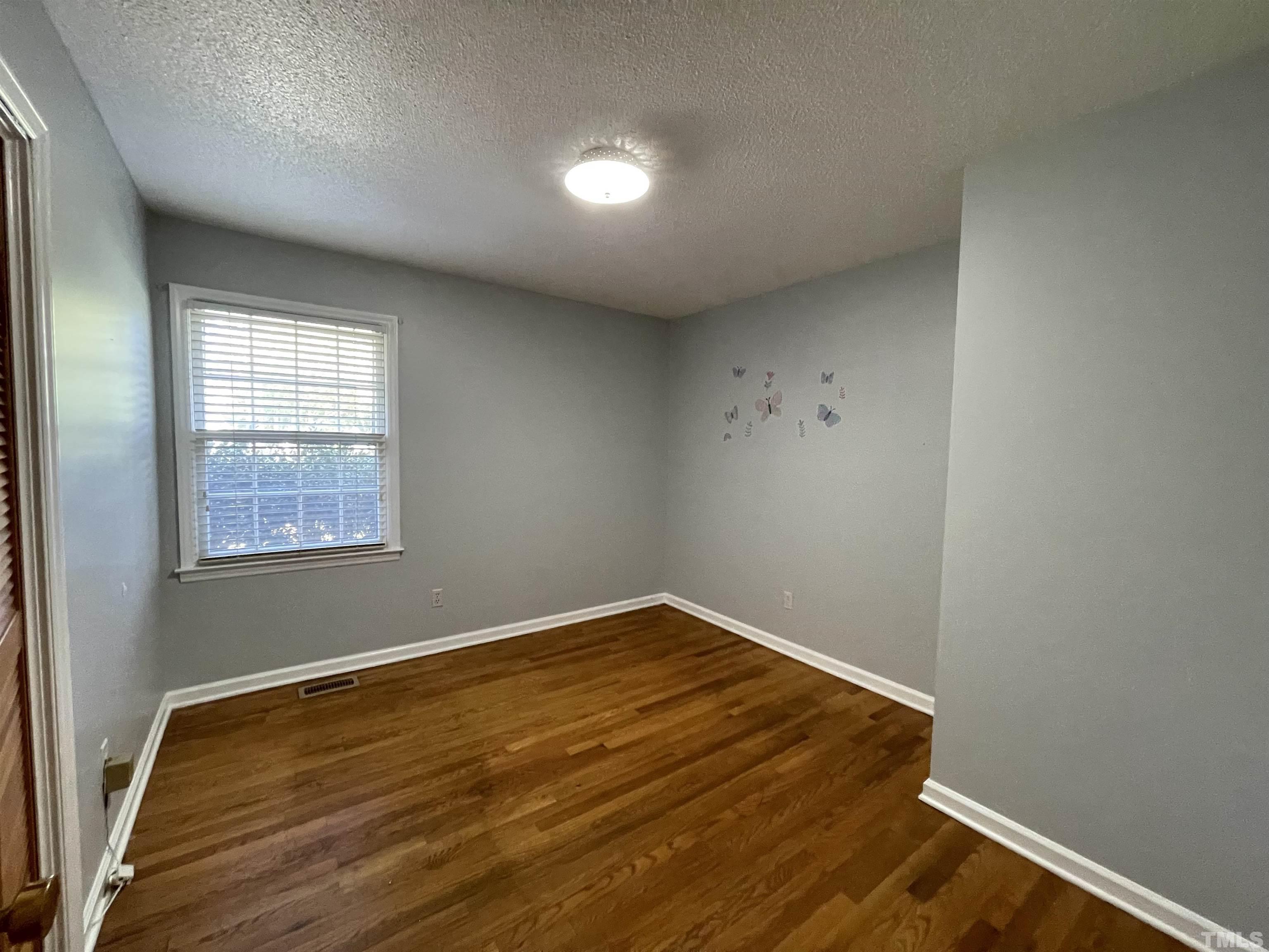 2995 Government Road Clayton, NC 27520 - Photo 10 of 15 an empty room with wooden floor and windows