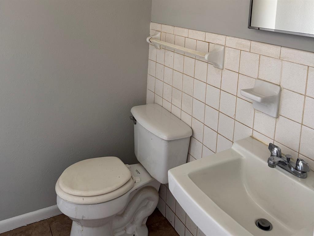 1413 Phillips Street Cleburne, TX 76033 - Photo 5 of 14 a white toilet sitting next to a bath tub