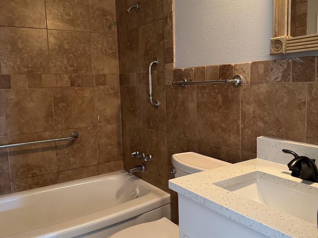 1413 Phillips Street Cleburne, TX 76033 - Photo 6 of 14 a bathroom with a sink and a bathtub