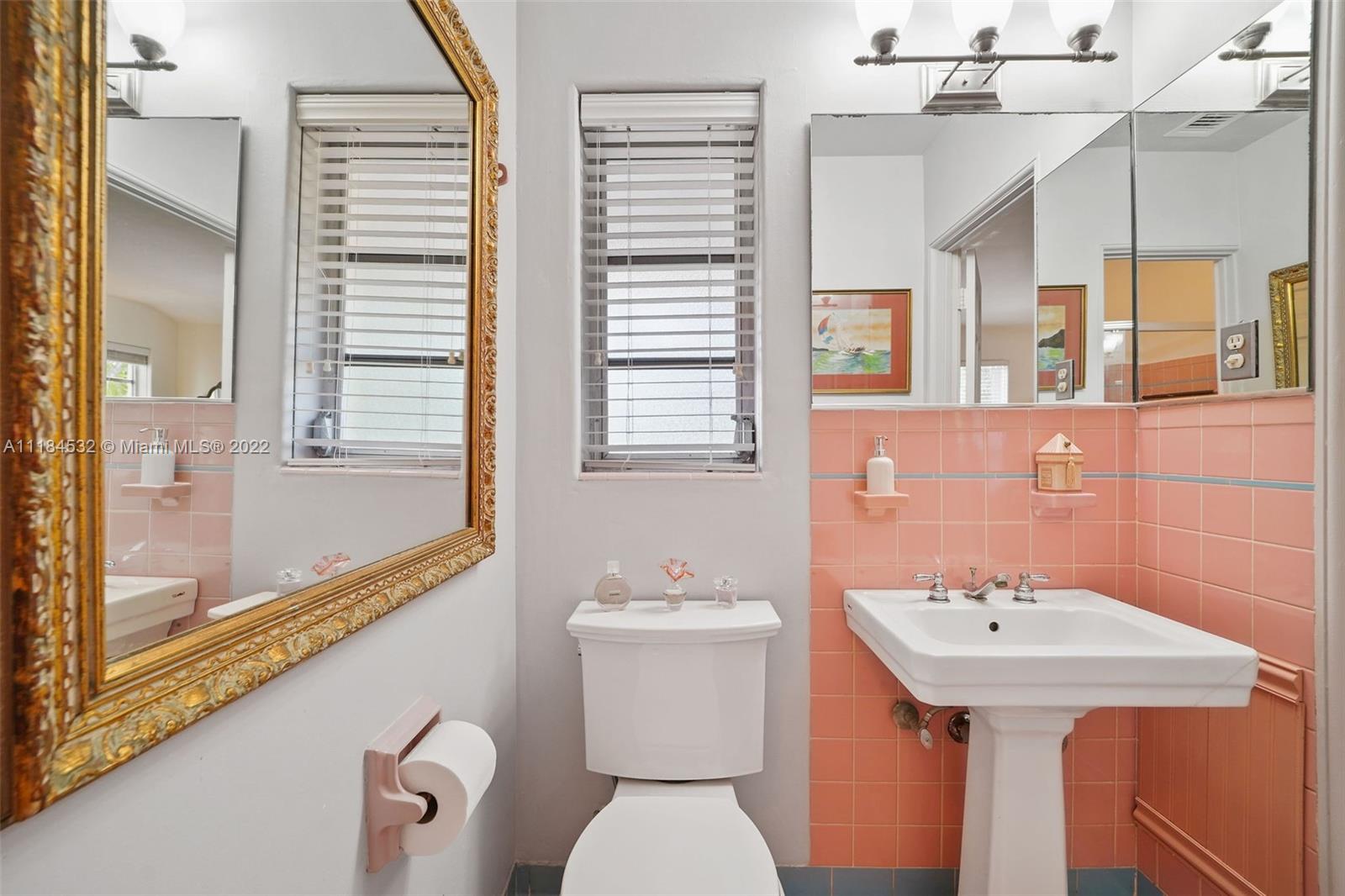 5842 Alton Road Miami Beach, FL 33140 - Photo 11 of 36 a bathroom with a sink a toilet and mirror