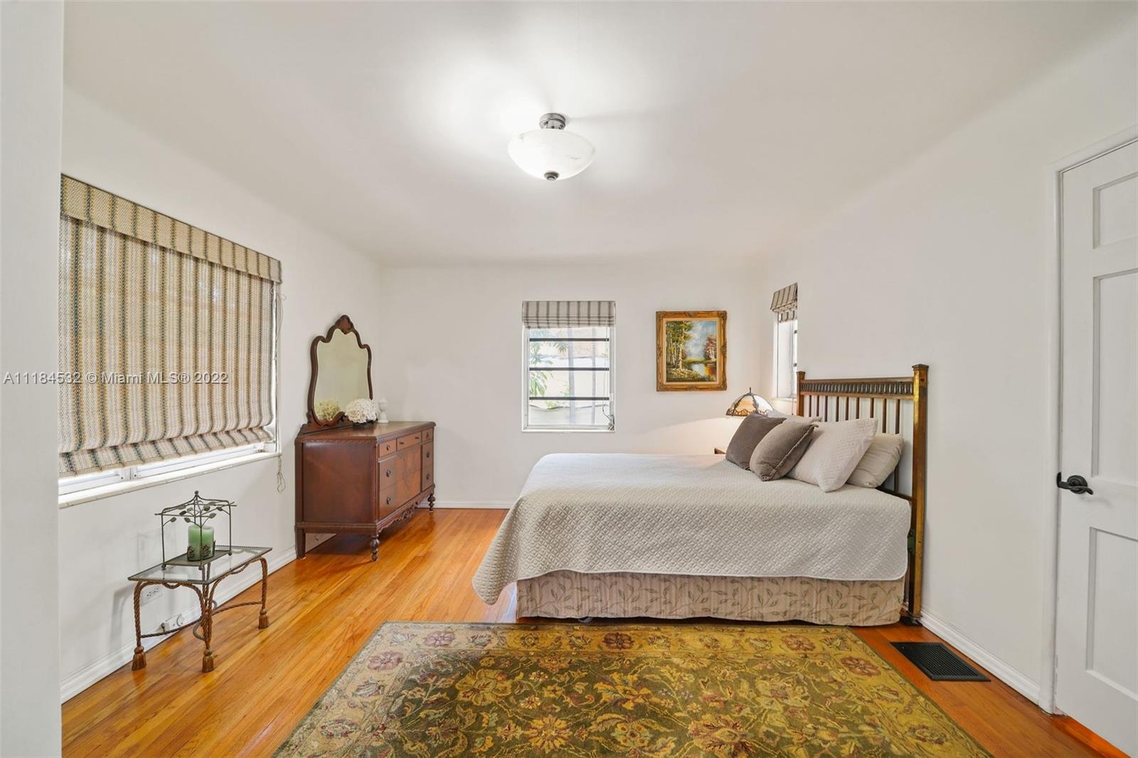 5842 Alton Road Miami Beach, FL 33140 - Photo 12 of 36 a bedroom with a large bed and a window