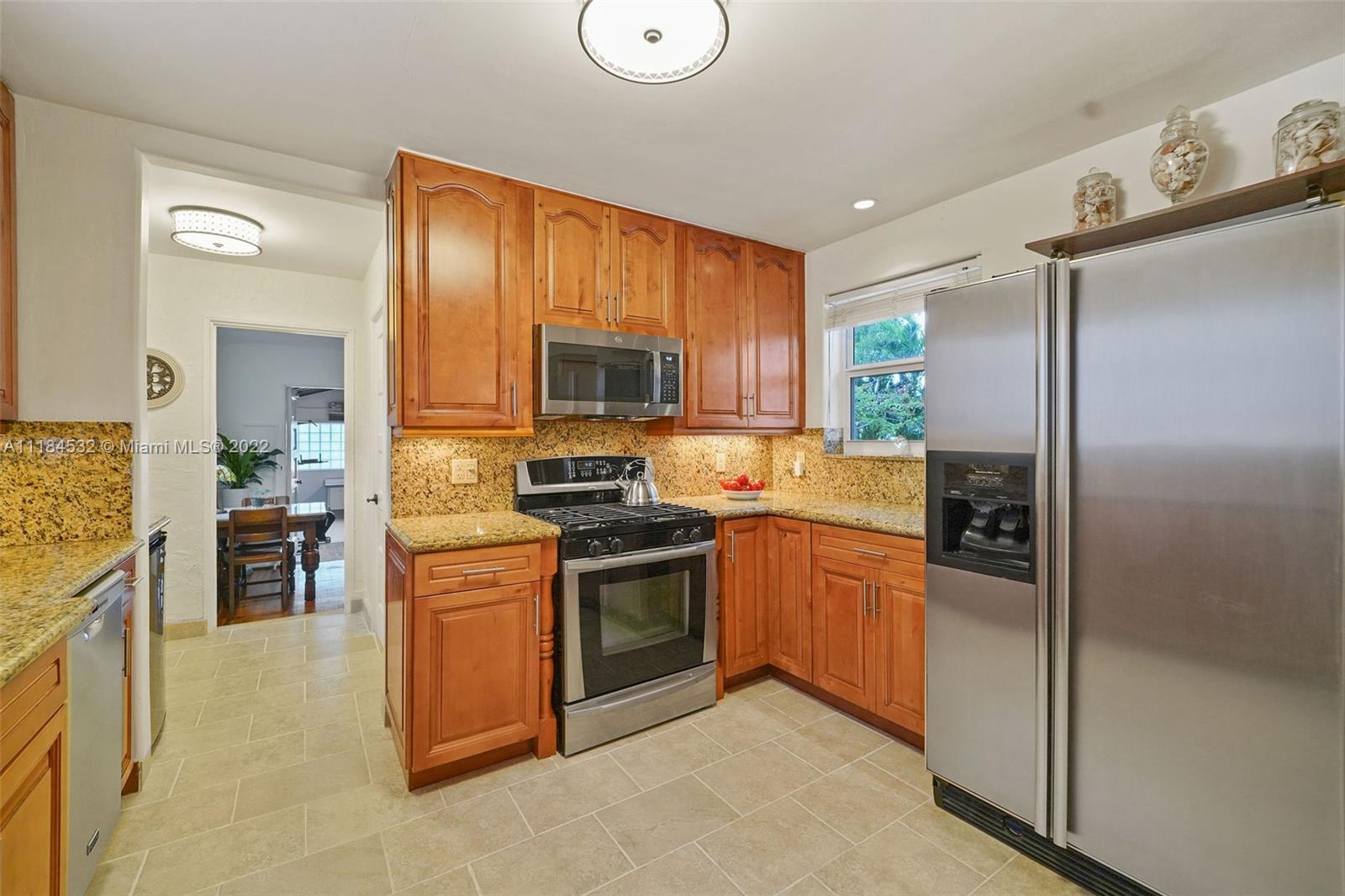 5842 Alton Road Miami Beach, FL 33140 - Photo 7 of 36 a kitchen with stainless steel appliances granite countertop a refrigerator stove and sink