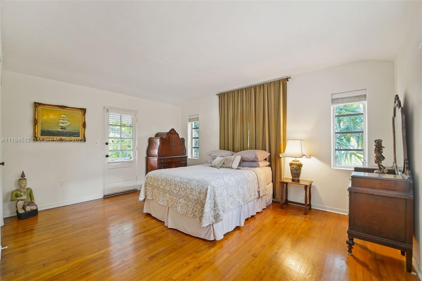 5842 Alton Road Miami Beach, FL 33140 - Photo 9 of 36 a spacious bedroom with a bed and wooden floor