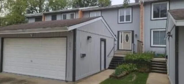 a view of a white house next to a yard