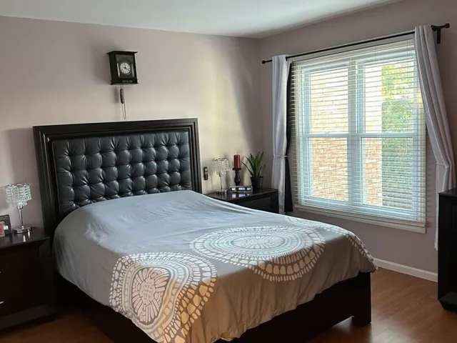 a bedroom with a bed and a flat tv screen on dresser