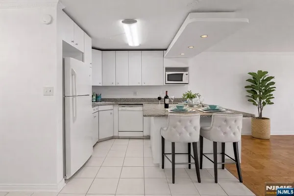 a kitchen with appliances cabinets table and chairs
