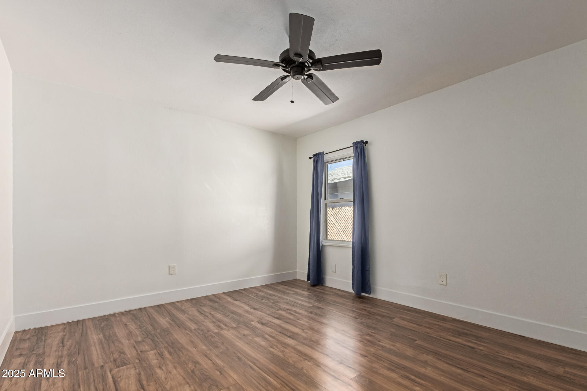 709 East Edison Avenue Buckeye, AZ 85326 - Photo 17 of 33 a view of empty room with wooden floor and fan