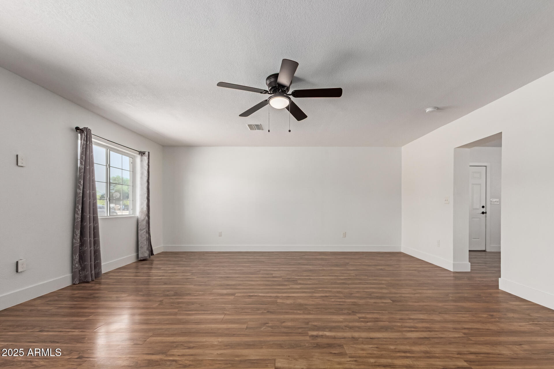 709 East Edison Avenue Buckeye, AZ 85326 - Photo 8 of 33 wooden floor in an empty room with a window