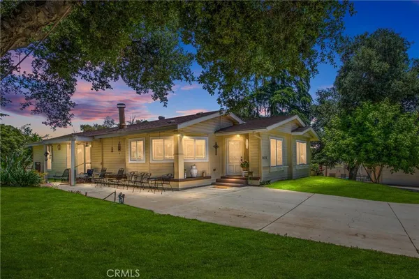 a front view of a house with a yard and trees