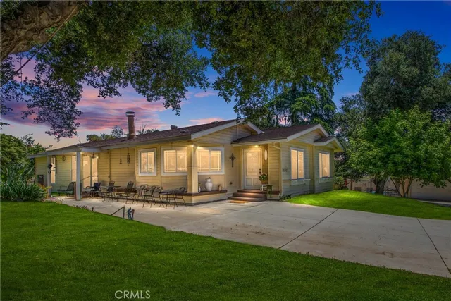 a front view of a house with a yard and trees