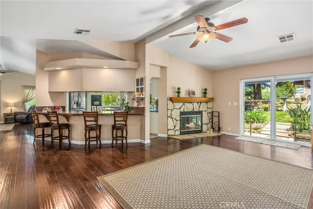 a kitchen with kitchen island granite countertop a table chairs sink and cabinets
