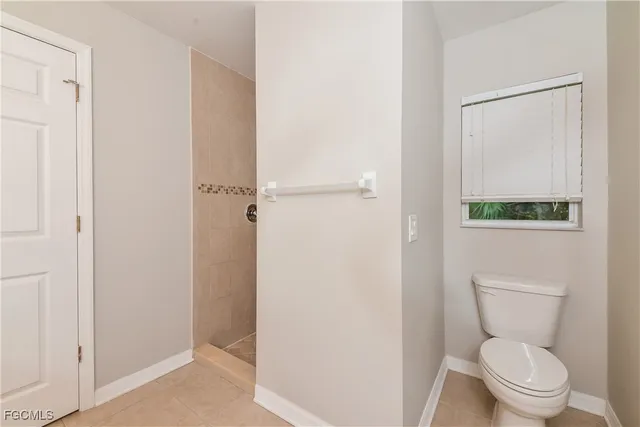 a white toilet sitting next to a shower