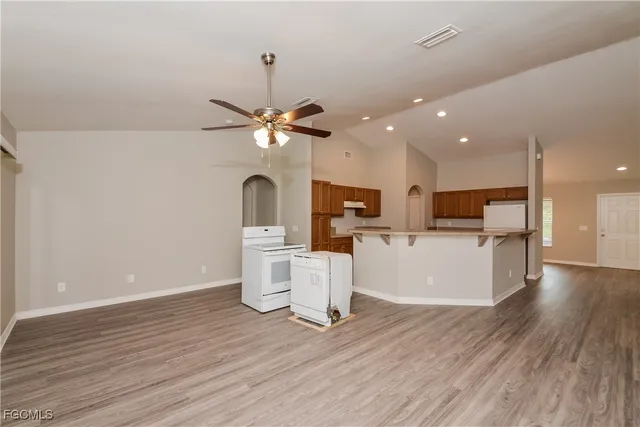 a view of kitchen with microwave a refrigerator and cabinets