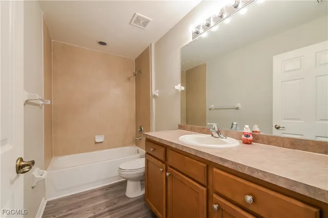 a bathroom with a granite countertop sink a toilet and shower