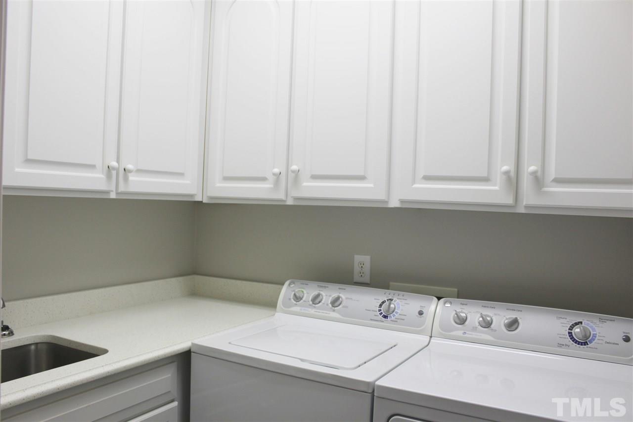 825 Rivers Edge Drive Graham, NC 27253 - Photo 11 of 25 Main floor laundry with utility sink, cabinets, washer & dryer