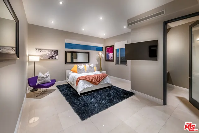 a bedroom with a bed and a flat screen tv