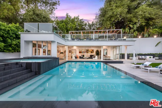 a view of a house with pool and chairs