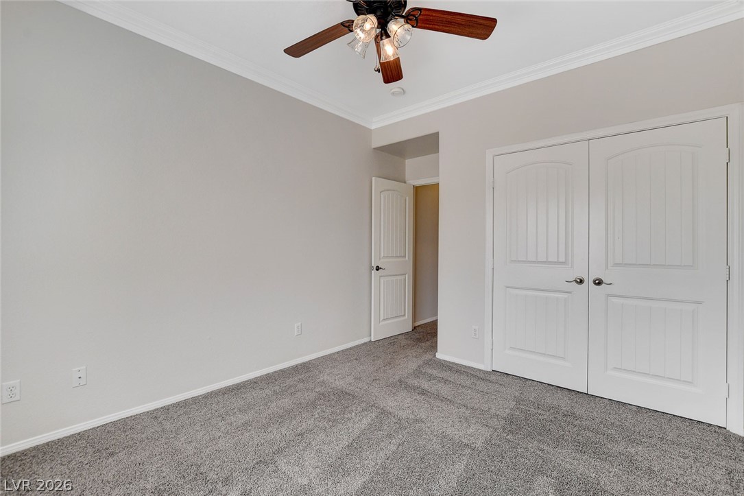 191 Verde Ridge Court Henderson, NV 89012 - Photo 25 of 36 Unfurnished bedroom with carpet floors, crown molding, baseboards, a closet, and ceiling fan