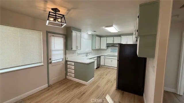 a kitchen with a refrigerator a sink and cabinets