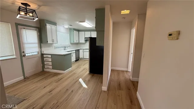 a kitchen with stainless steel appliances granite countertop a refrigerator a sink and wooden floor