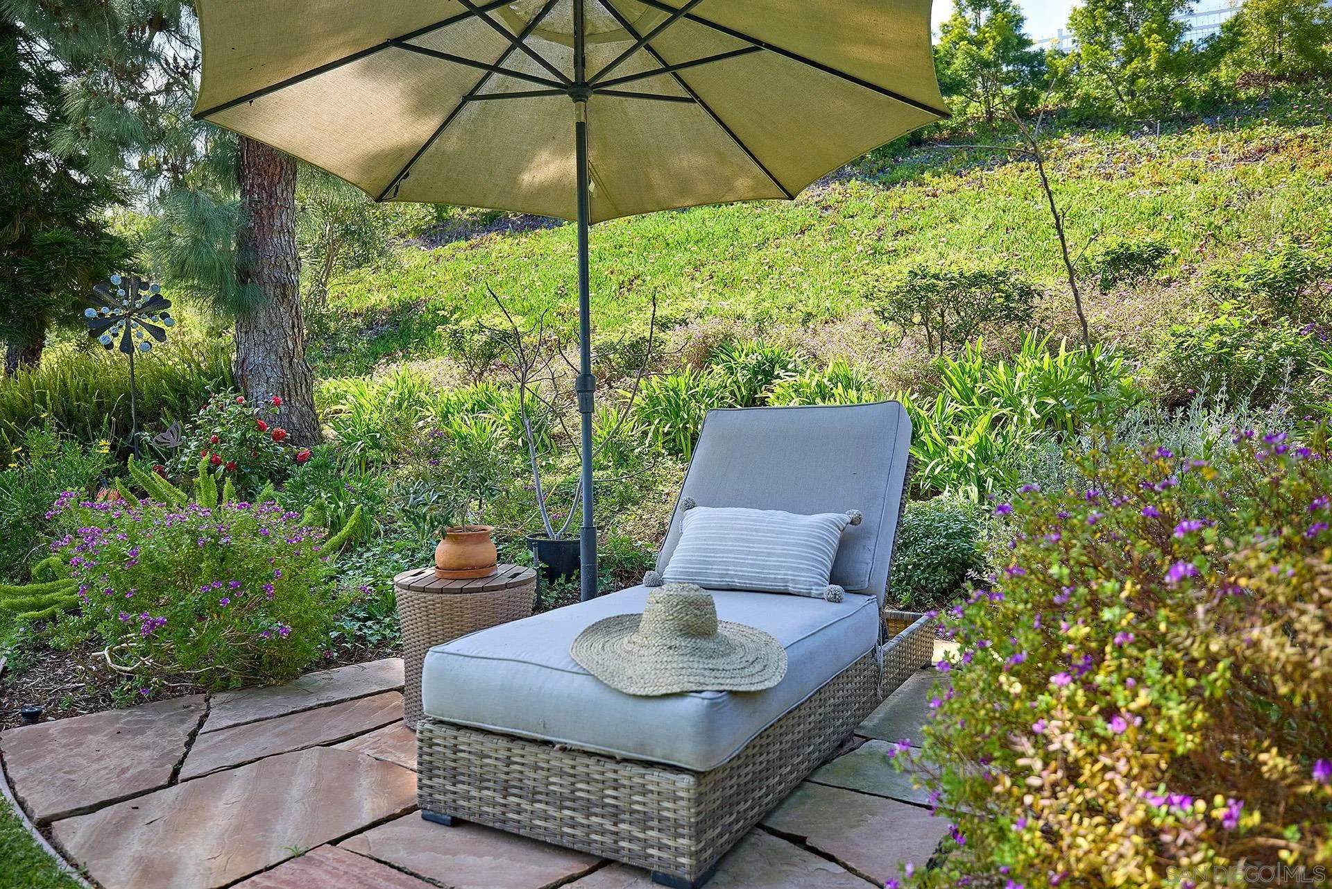 1229 Swallowtail Court Encinitas, CA 92024 - Photo 18 of 36 a backyard of a house with table and chairs under an umbrella