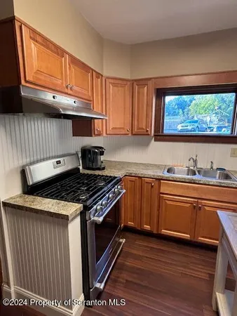 a kitchen with stainless steel appliances granite countertop a stove a sink and a microwave
