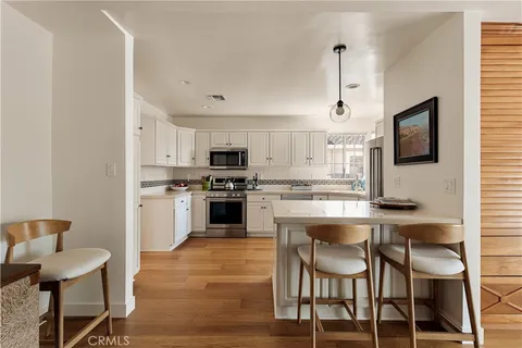 a kitchen with white cabinets and appliances