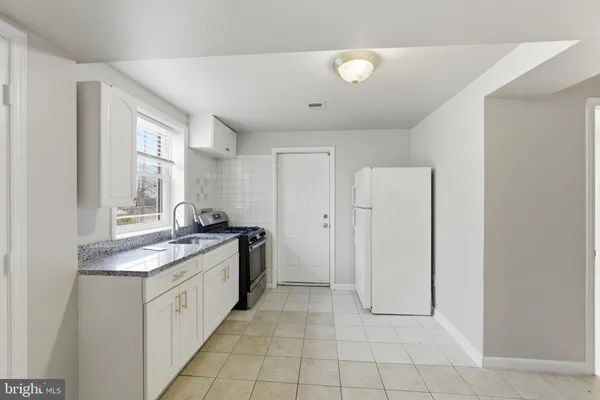 a view of a kitchen with a sink and a refrigerator cabinets