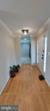 an empty room with wooden floor fireplace and windows