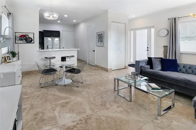 a kitchen with stainless steel appliances granite countertop a sink a stove a refrigerator cabinets and a dining table