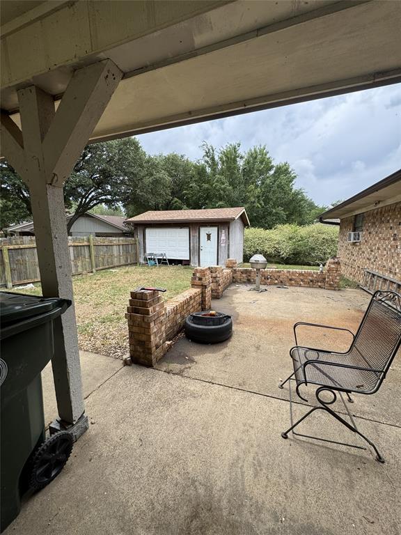 636 East Kempner Street Mabank, TX 75147 - Photo 10 of 28 Covered concrete patio with overhead wood beam structure, brick half-walls, and backyard access