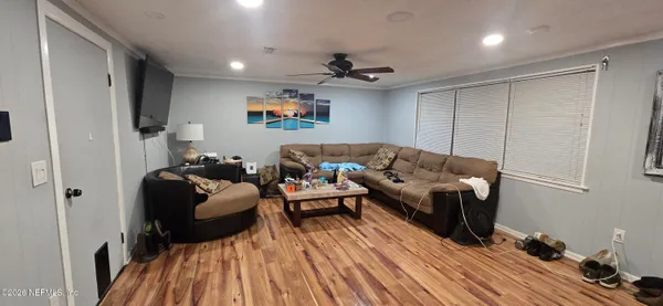 a living room with furniture and a wooden floor
