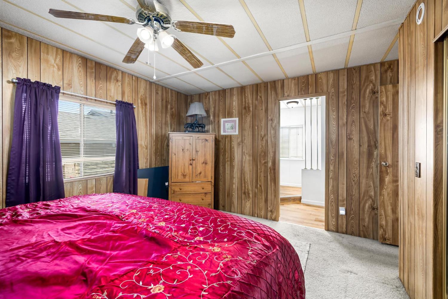 1200 South Carpenter Road, Unit 4 Modesto, CA 95351 - Photo 17 of 31 Bedroom featuring wood-finish paneling, a ceiling fan with light fixture, carpeted flooring, and a window with blinds