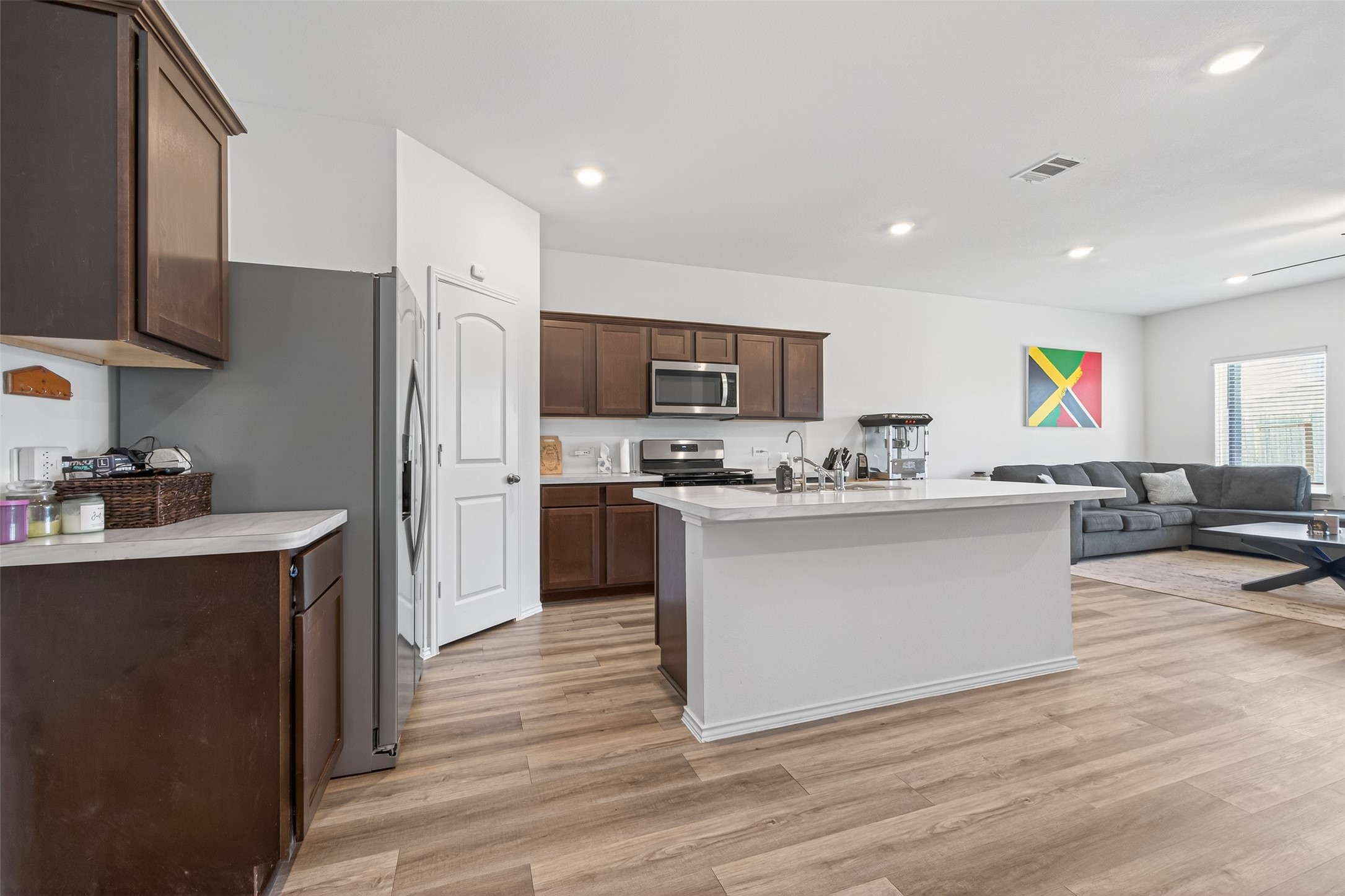23532 Nectar Crest Heights Splendora, TX 77372 - Photo 4 of 21 a kitchen with kitchen island granite countertop wooden floors stainless steel appliances a sink and a refrigerator