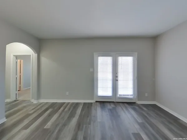 an empty room with wooden floor and window