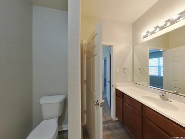 a bathroom with a sink a toilet a mirror and shower