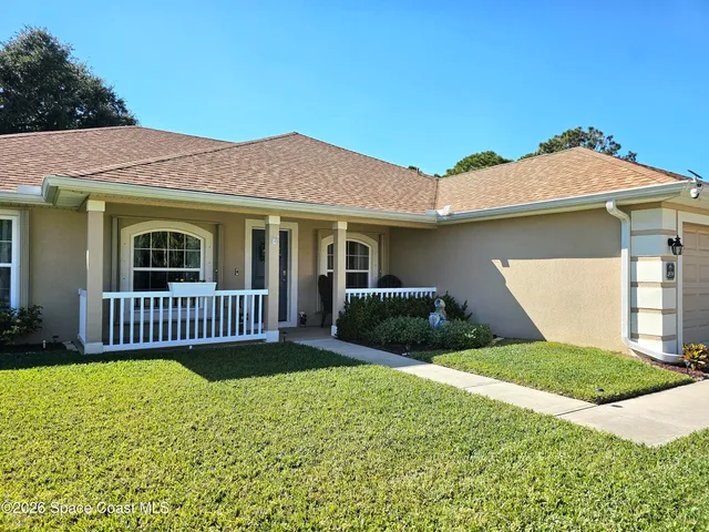 a view of a house with a yard and porch