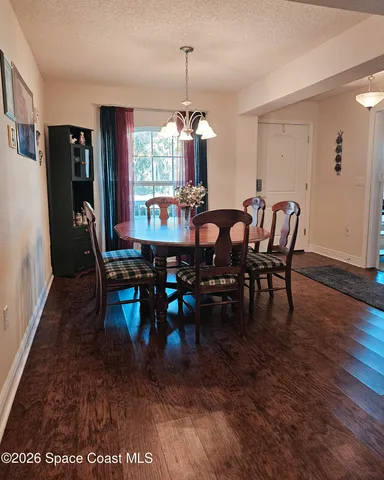 a dining room with furniture a chandelier and wooden floor