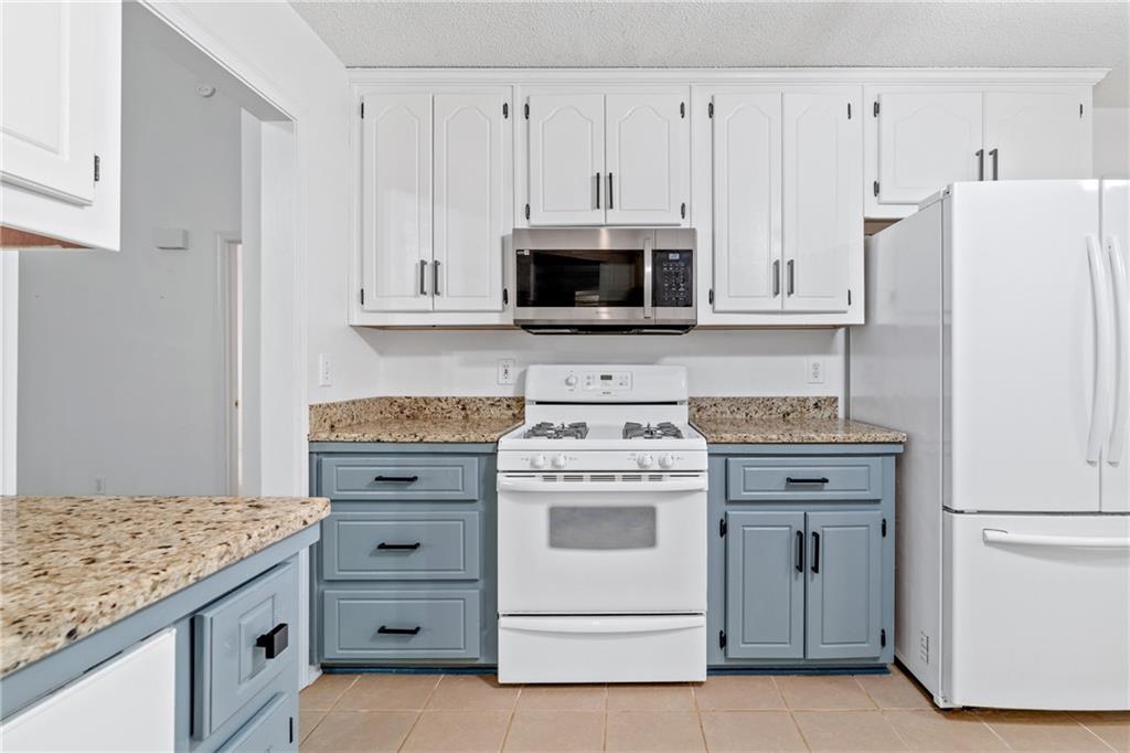204 Red Fox Court Canton, GA 30114 - Photo 14 of 51 a kitchen with granite countertop white cabinets and white appliances