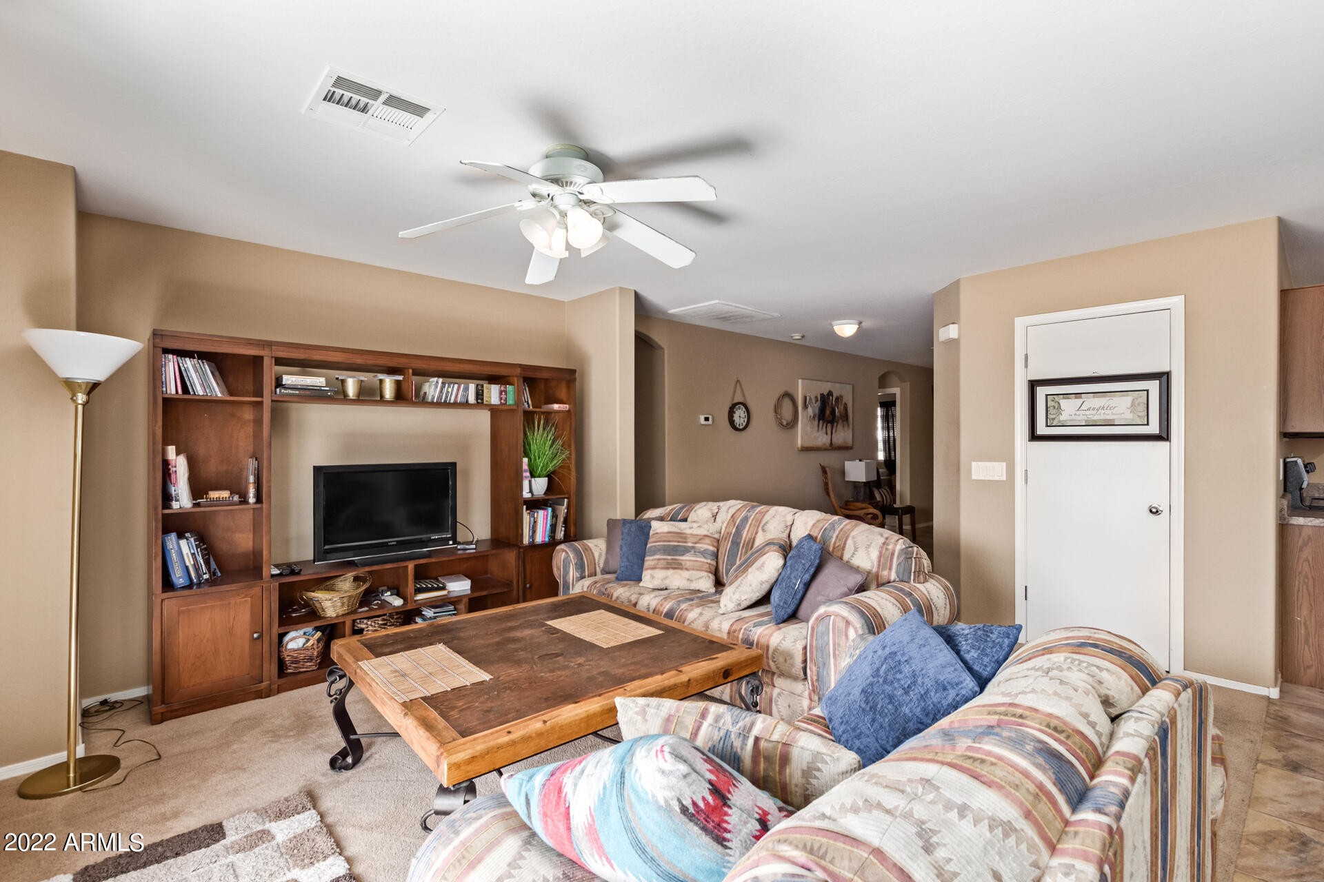 2742 South Powell Road Apache Junction, AZ 85119 - Photo 12 of 34 a living room with furniture a flat screen tv and a fireplace