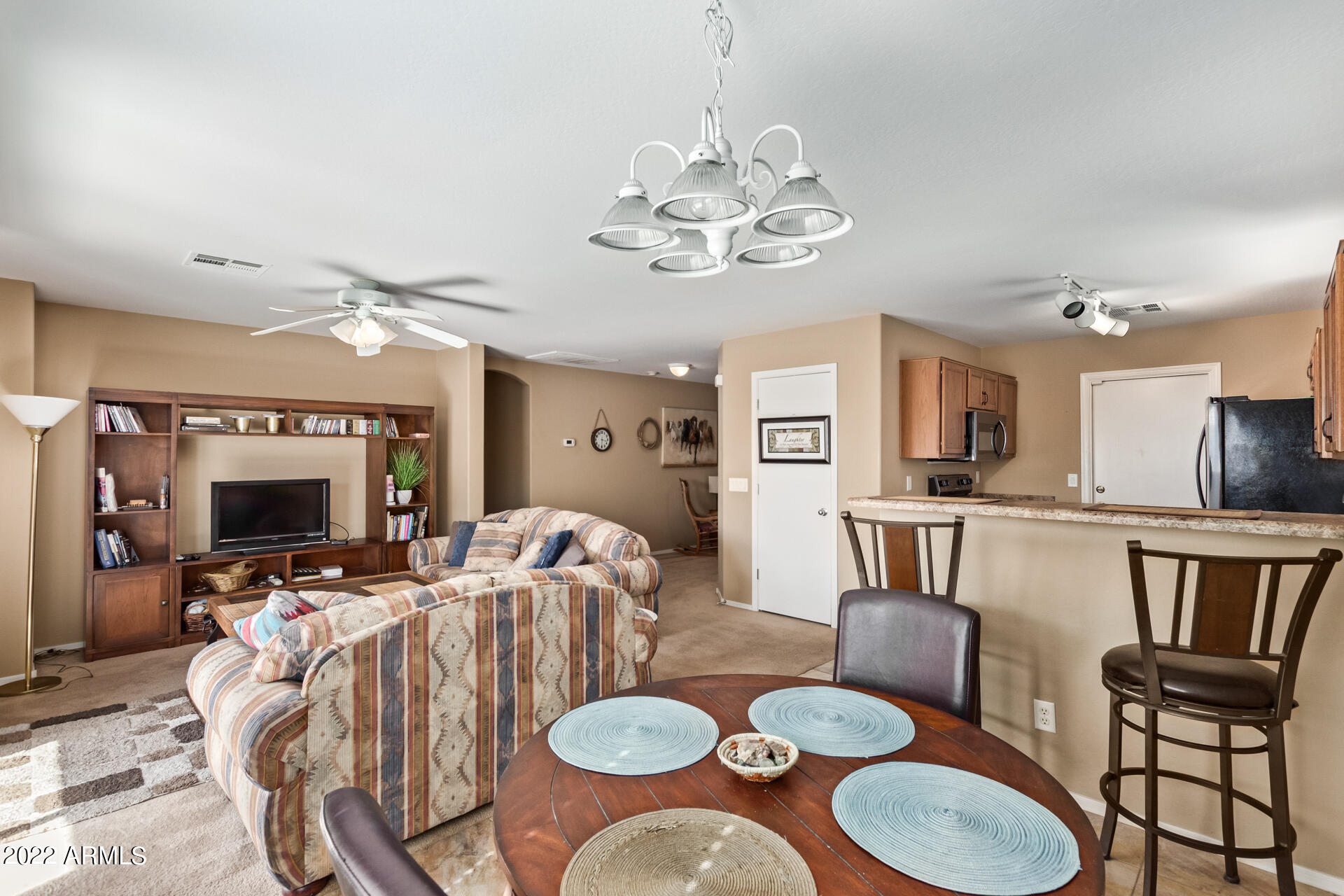 2742 South Powell Road Apache Junction, AZ 85119 - Photo 15 of 34 a view of a dining room with furniture a chandelier and wooden floor