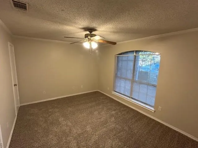 an empty room with windows and fan