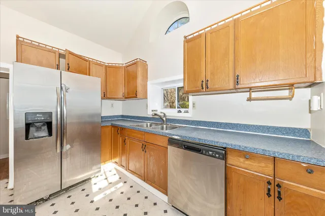 a kitchen with stainless steel appliances a refrigerator sink and cabinets