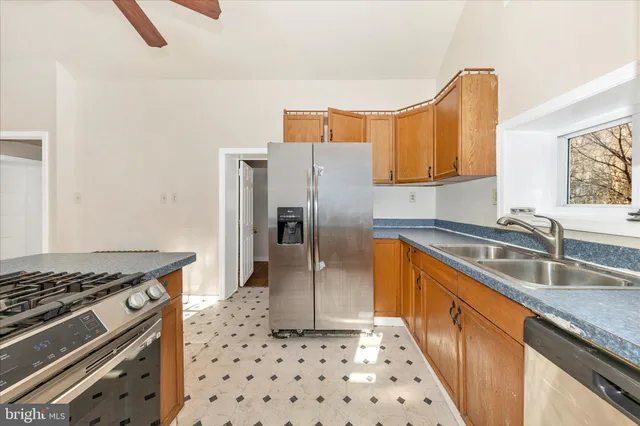a kitchen with granite countertop a sink stove and refrigerator