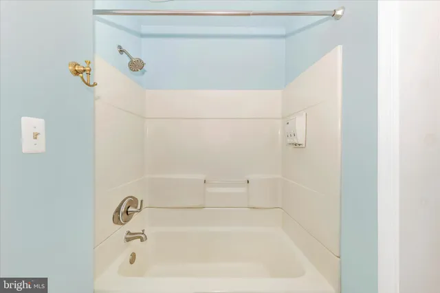 a view of a livingroom with a chandelier fan and windows