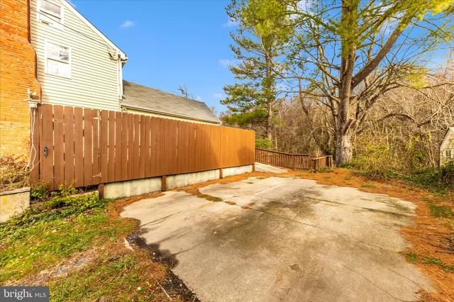 a view of a yard with wooden fence