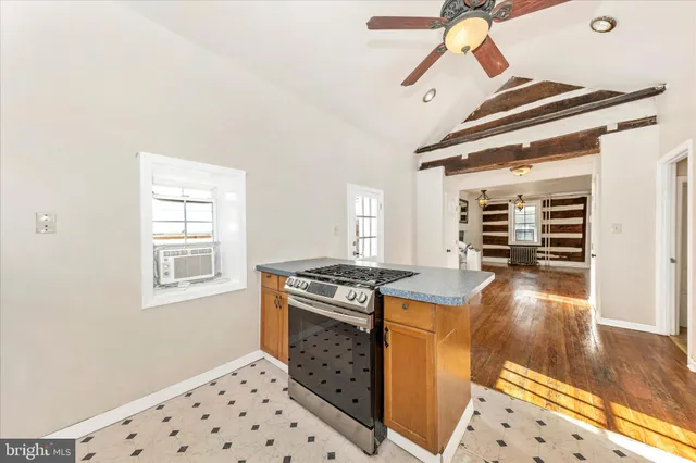 a kitchen with granite countertop a stove and a wooden floor