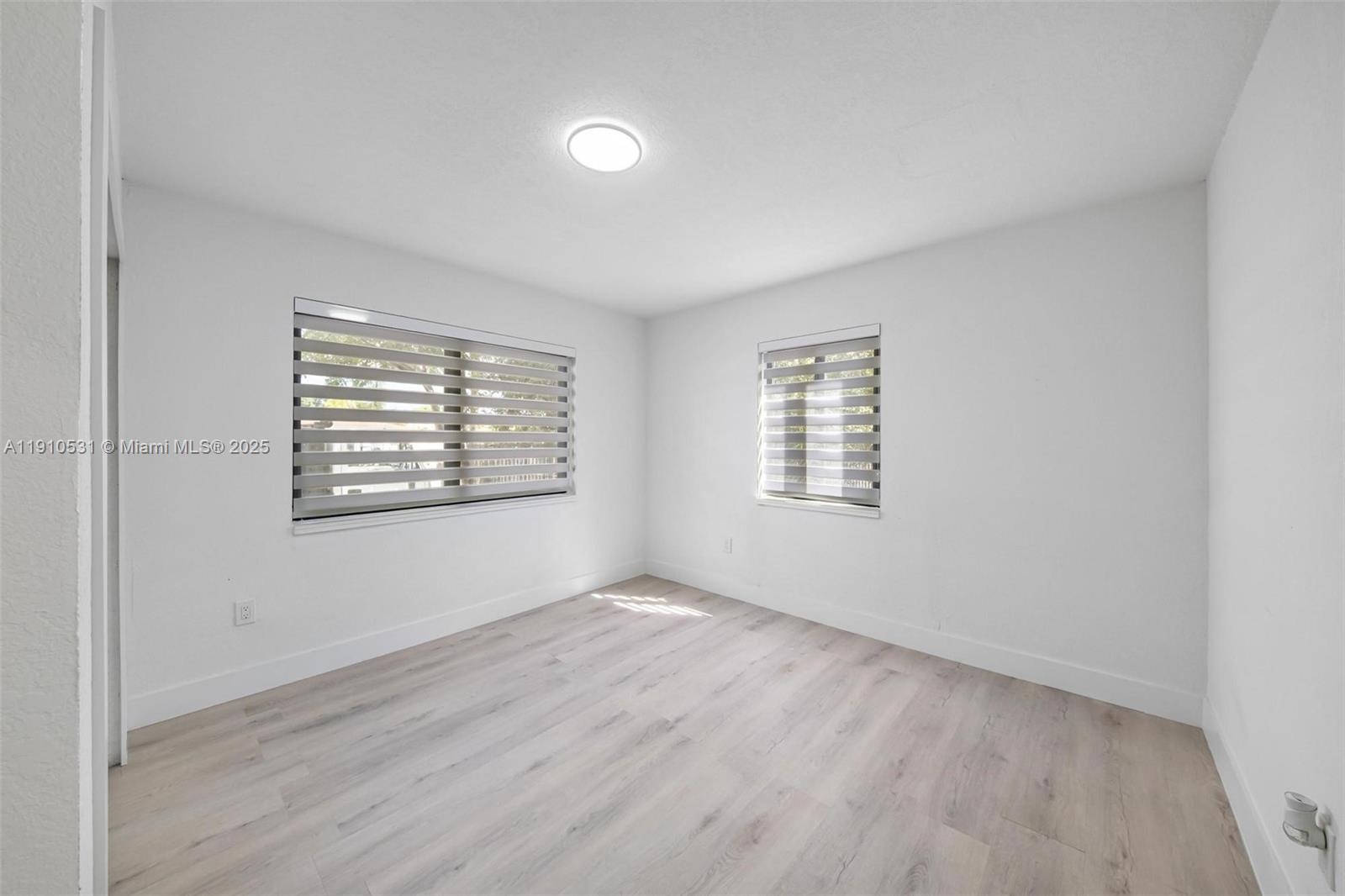 2250 Northwest 95th Street Miami, FL 33147 - Photo 12 of 26 an empty room with wooden floor and windows