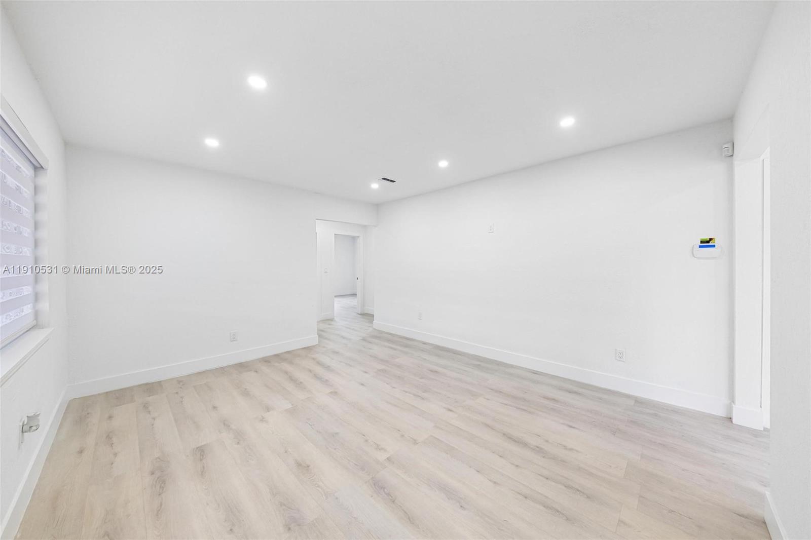 2250 Northwest 95th Street Miami, FL 33147 - Photo 4 of 26 an empty room with wooden floor and windows