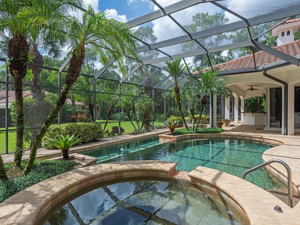 5140 Tamarind Ridge Drive Naples, FL 34119 - Photo 24 of 25 Mediterranean-style architecture with a tile roof, a circular paver driveway, lush landscaping.Visible behind the home a free standing building with three (3) additional garages and a half bath.
